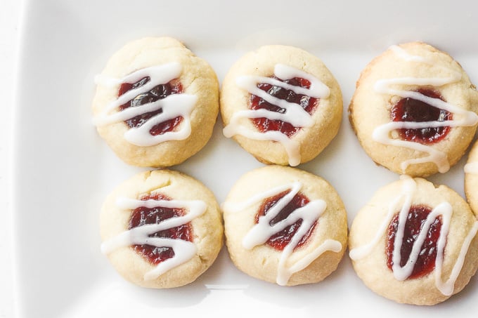 Soft, buttery, melt-in-your mouth jam-filled thumbprint cookies with almond glaze are the cutest, festive treat to make. | aheadofthyme.com