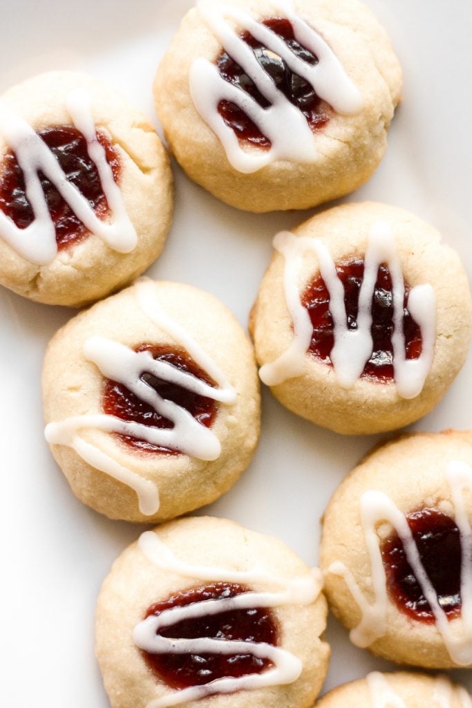 Soft, buttery, melt-in-your mouth jam-filled thumbprint cookies with almond glaze are the cutest, festive treat to make. | aheadofthyme.com