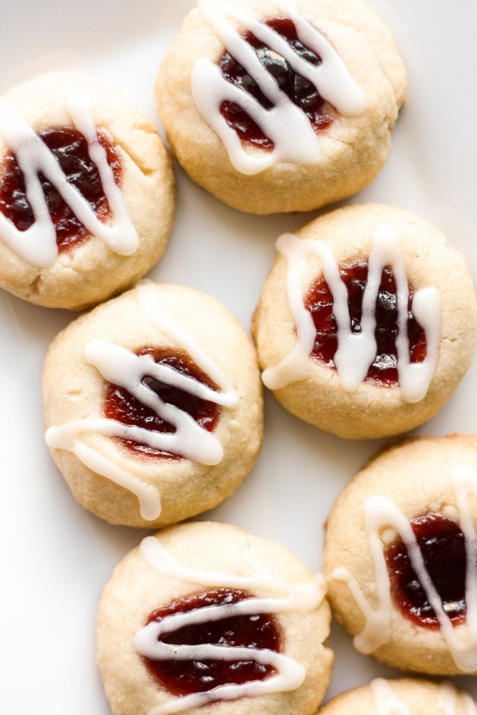 Weiche, butterartige, mit Marmelade gefüllte Thumbprint-Kekse mit Mandelglasur sind der süßeste, festlichste Leckerbissen. / aheadofthyme.com