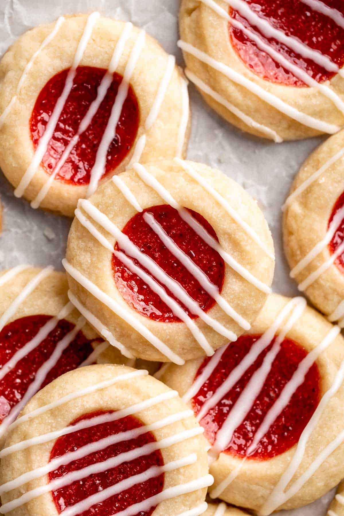 Jam Thumbprint Cookies are soft and buttery, with a sweet and fruity jam filling, and a drizzle of almond glaze. They literally melt in your mouth! | aheadofthyme.com