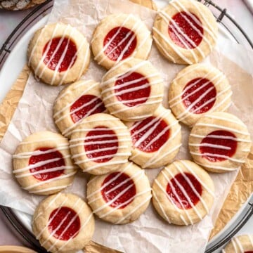 Jam Thumbprint Cookies are soft and buttery, with a sweet and fruity jam filling, and a drizzle of almond glaze. They literally melt in your mouth! | aheadofthyme.com