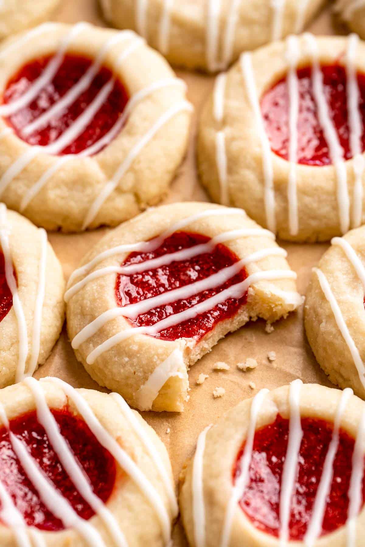 Jam Thumbprint Cookies are soft and buttery, with a sweet and fruity jam filling, and a drizzle of almond glaze. They literally melt in your mouth! | aheadofthyme.com