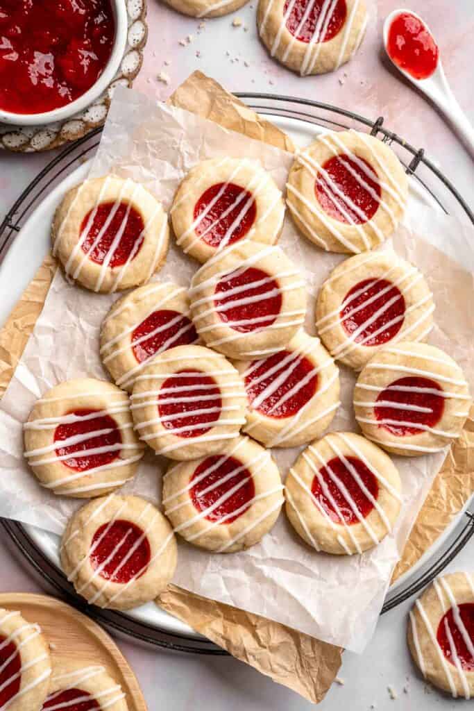 Jam Thumbprint Cookies are soft and buttery, with a sweet and fruity jam filling, and a drizzle of almond glaze. They literally melt in your mouth! | aheadofthyme.com