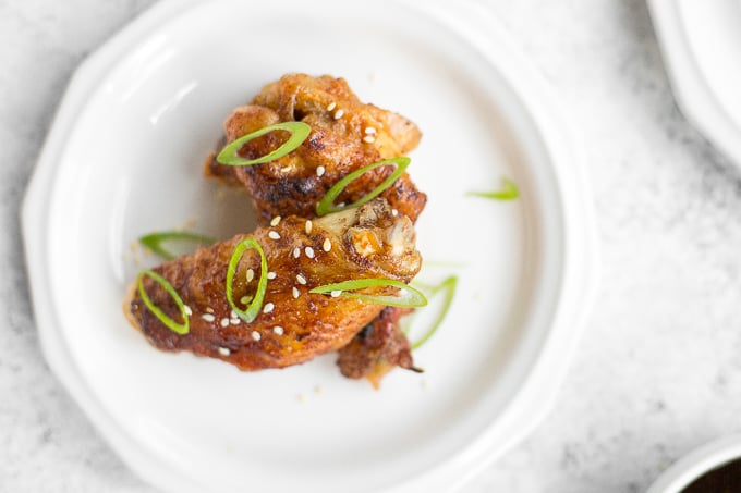 You will be amazed by how crispy these baked Asian chicken wings turn out! We add sriracha for heat, honey for sweetness, and ginger to balance the flavours. | aheadofthyme.com