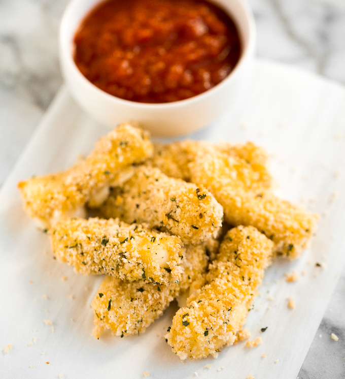 Crunchy, cheesy, and paired with an awesome dipping sauce, these baked mozzarella sticks are just as amazing as what you would find in a restaurant! | aheadofthyme.com
