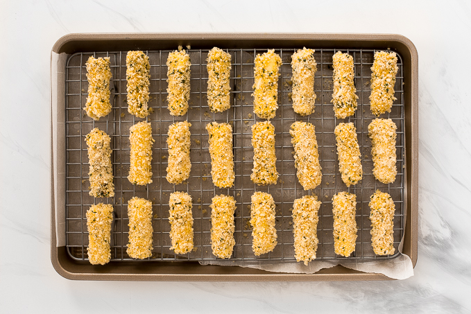 Crunchy, cheesy, and paired with an awesome dipping sauce, these baked mozzarella sticks are just as amazing as what you would find in a restaurant! | aheadofthyme.com