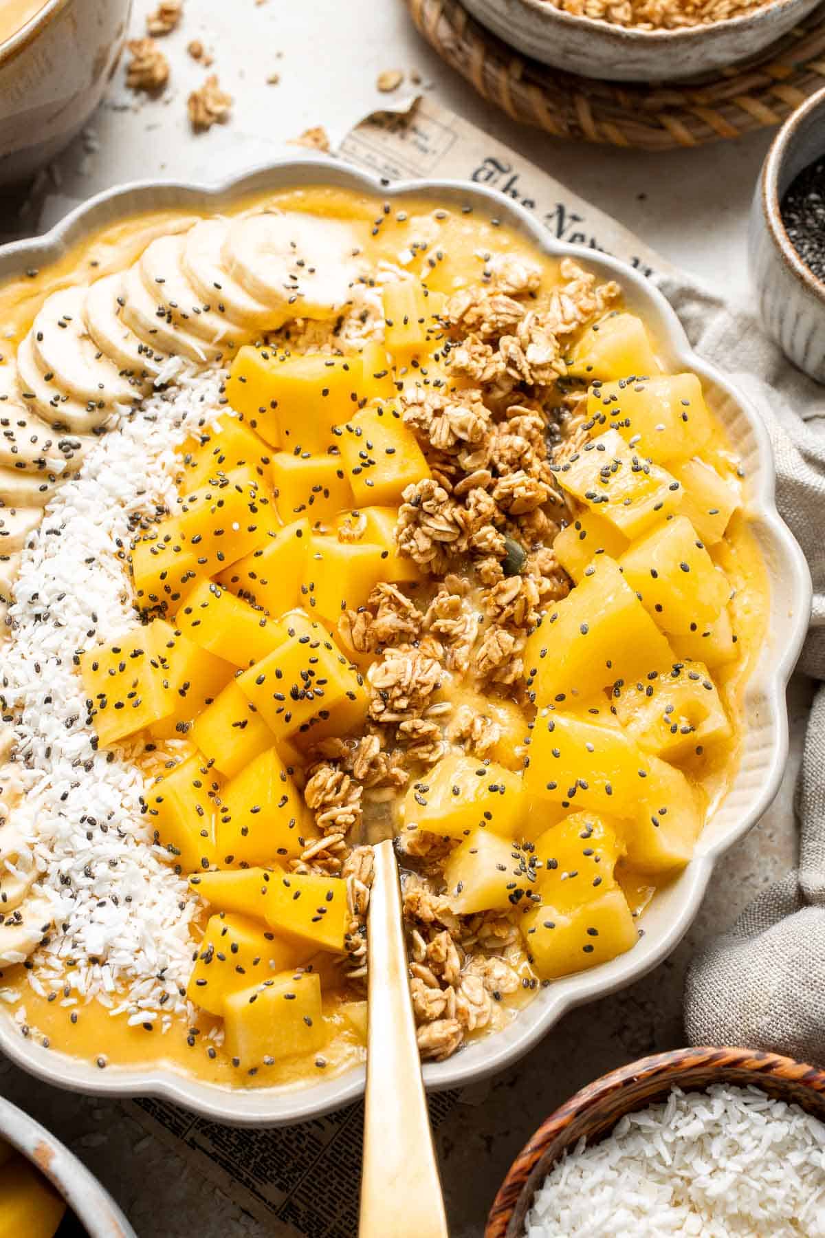 Mango Pineapple Tropical Smoothie Bowl is the perfect summer bowl, packed with pineapples and mangos and topped with more fruit, granola, and coconut. | aheadofthyme.com