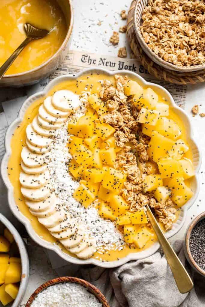 Mango Pineapple Tropical Smoothie Bowl is the perfect summer bowl, packed with pineapples and mangos and topped with more fruit, granola, and coconut. | aheadofthyme.com