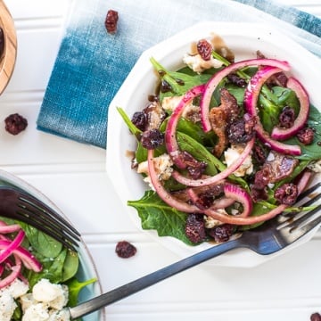 Every bite of pickled red onion and blue cheese spinach salad is the perfect bite! The bold flavors of blue cheese, maple bacon, and dried cranberries compliment the pickled red onions, creating the perfectly balanced dish — salty, sweet, acidic. | aheadofthyme.com