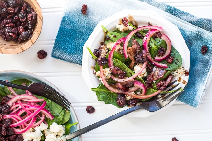 Every bite of pickled red onion and blue cheese spinach salad is the perfect bite! The bold flavors of blue cheese, maple bacon, and dried cranberries compliment the pickled red onions, creating the perfectly balanced dish — salty, sweet, acidic. | aheadofthyme.com