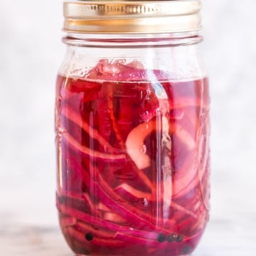These quick and easy pickled red onions are going to change your life. They are incredibly versatile and add amazing acidity to otherwise simple dishes. I put them on everything from tacos to scrambled eggs to salads and sandwiches. | aheadofthyme.com