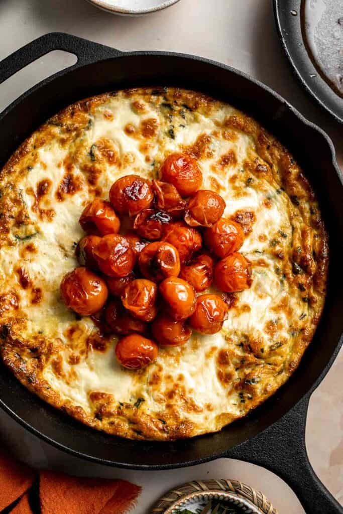 Caprese Frittata is light and fluffy, laced with fresh basil and topped with melted mozzarella cheese and blistered balsamic tomatoes. Ready in 10 minutes! | aheadofthyme.com