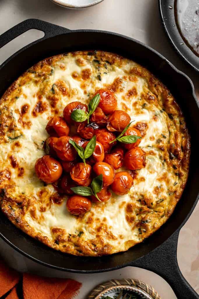 Caprese Frittata is light and fluffy, laced with fresh basil and topped with melted mozzarella cheese and blistered balsamic tomatoes. Ready in 10 minutes! | aheadofthyme.com