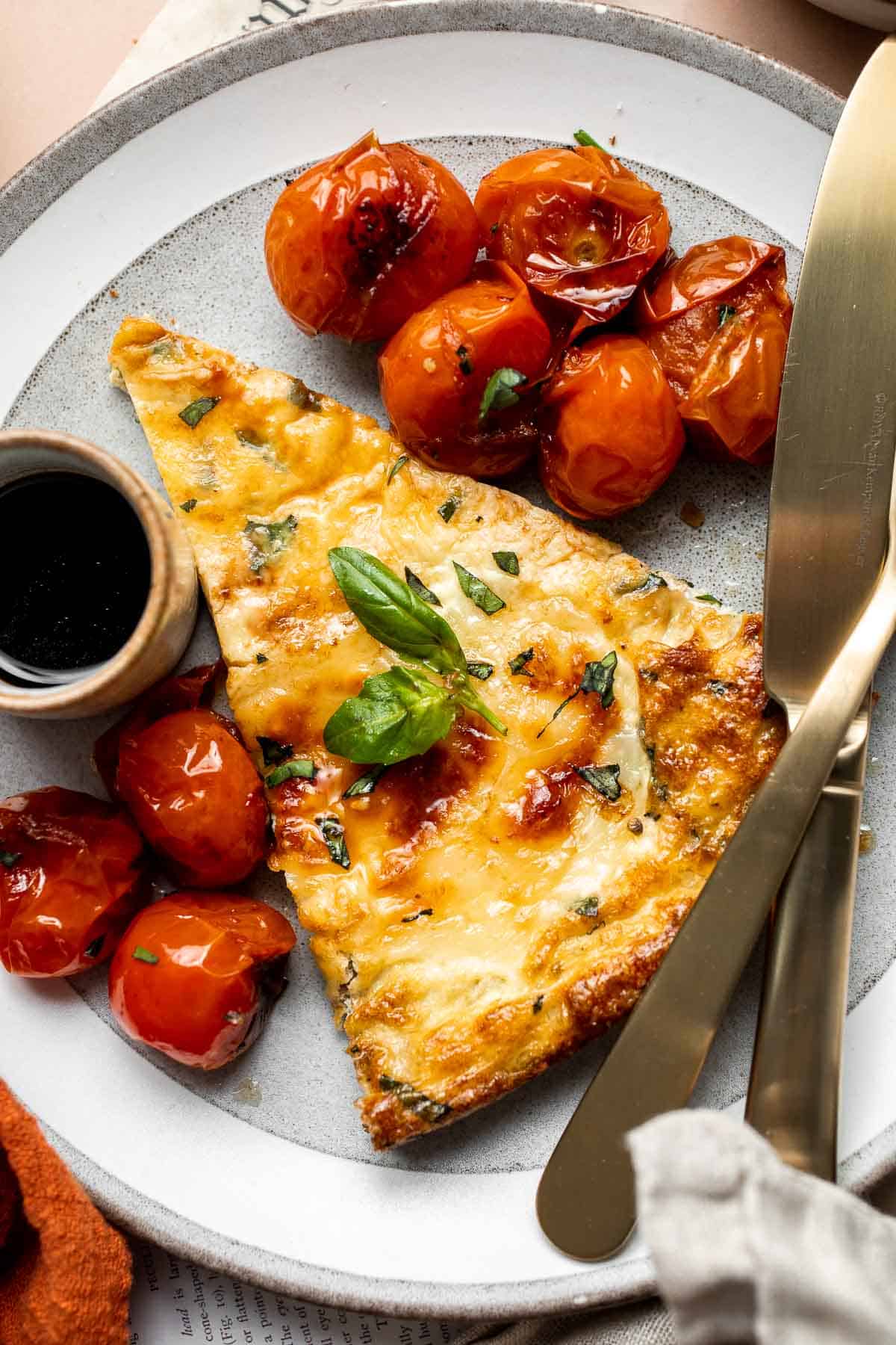 Caprese Frittata is light and fluffy, laced with fresh basil and topped with melted mozzarella cheese and blistered balsamic tomatoes. Ready in 10 minutes! | aheadofthyme.com