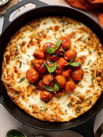 Caprese Frittata is light and fluffy, laced with fresh basil and topped with melted mozzarella cheese and blistered balsamic tomatoes. Ready in 10 minutes! | aheadofthyme.com