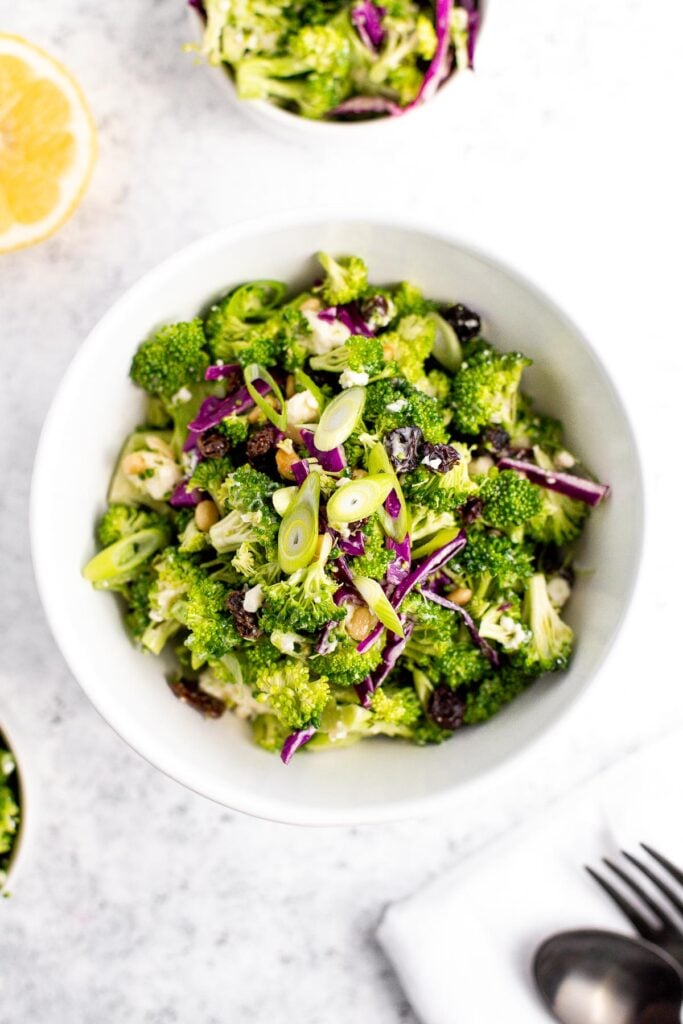 Creamy broccoli slaw salad is healthy, delicious, and flavourful. It's packed with crunchy vegetables, salty feta, sweet raisins, and a creamy dressing. | aheadofthyme.com