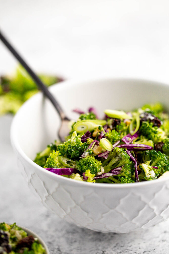 Creamy broccoli slaw salad is healthy, delicious, and flavourful. It's packed with crunchy vegetables, salty feta, sweet raisins, and a creamy dressing. | aheadofthyme.com