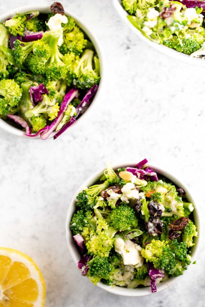 Creamy broccoli slaw salad is healthy, delicious, and flavourful. It's packed with crunchy vegetables, salty feta, sweet raisins, and a creamy dressing. | aheadofthyme.com