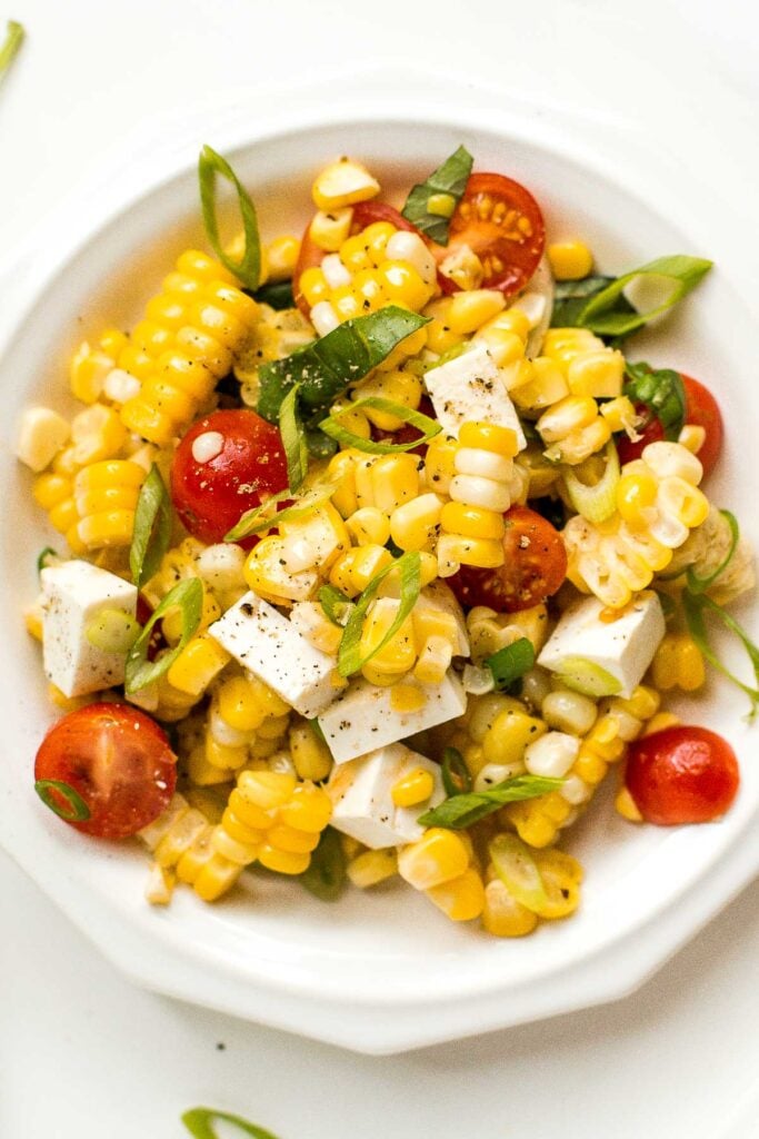 Take fresh-off-the-grill corn on the cob and turn it into a light, flavourful summer corn salad, topped with cherry tomatoes, fresh basil and cheese. | aheadofthyme.com