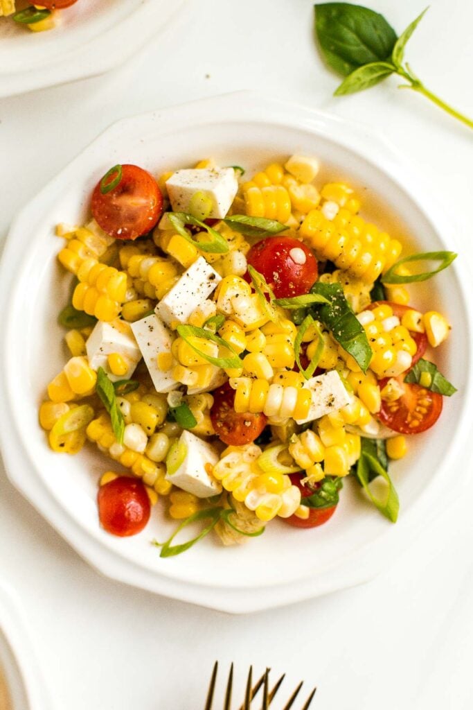 Take fresh-off-the-grill corn on the cob and turn it into a light, flavourful summer corn salad, topped with cherry tomatoes, fresh basil and cheese. | aheadofthyme.com