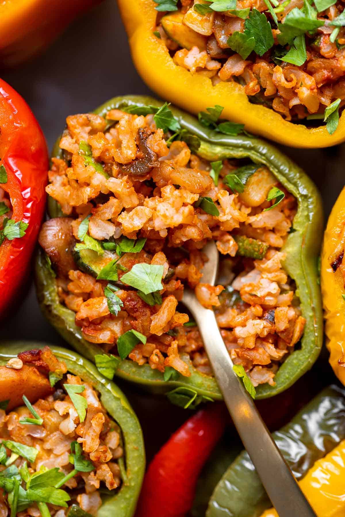 Vegan Stuffed Peppers are stuffed with pan-fried mushrooms, tender rice, and veggies, making them flavorful and filling. Easy to make in under an hour! | aheadofthyme.com