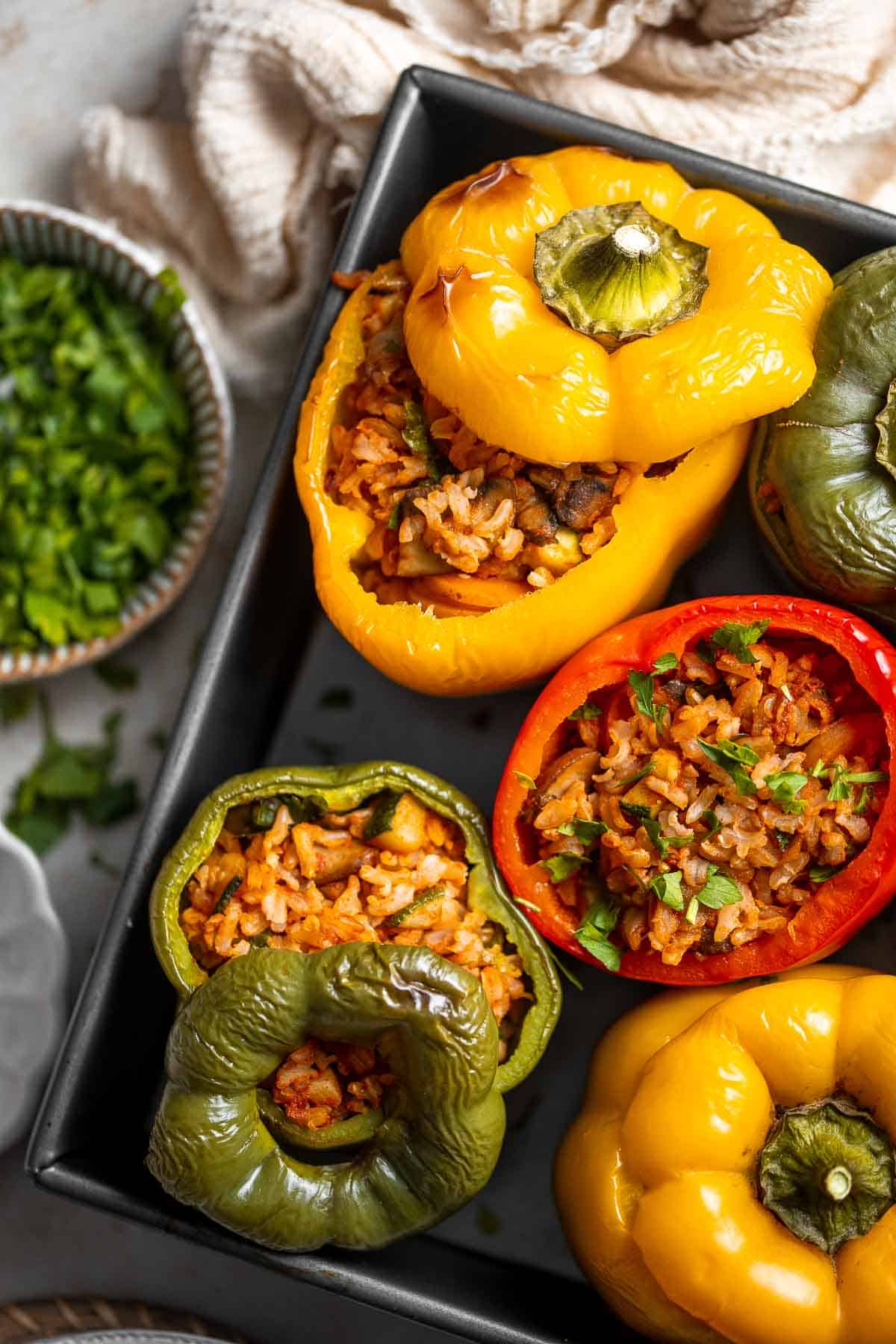 Vegan Stuffed Peppers are stuffed with pan-fried mushrooms, tender rice, and veggies, making them flavorful and filling. Easy to make in under an hour! | aheadofthyme.com