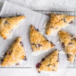 Glazed lemon blueberry scones are total breakfast goals! Blueberries and lemon partner together in a light, tender and flakey scone, drizzled with a sweet lemon glaze that is nothing short of impressive. | aheadofthyme.com