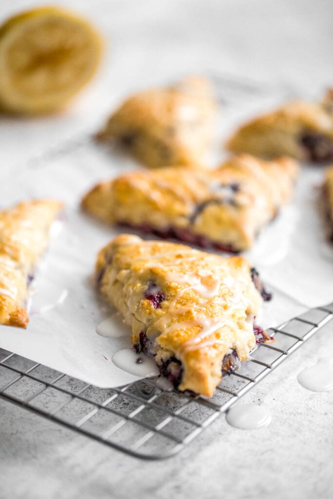 Light, tender and flakey, glazed lemon blueberry scones are crunchy and golden on the outside, soft and moist in the middle, with a drizzle of lemon glaze. | aheadofthyme.com