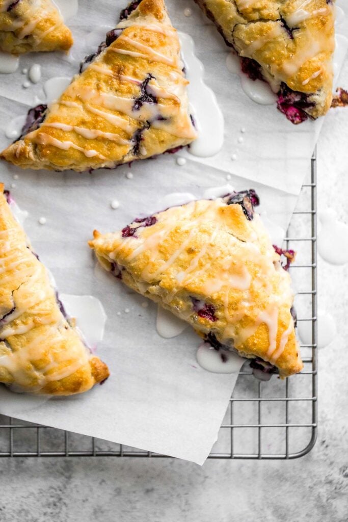 Light, tender and flakey, glazed lemon blueberry scones are crunchy and golden on the outside, soft and moist in the middle, with a drizzle of lemon glaze. | aheadofthyme.com