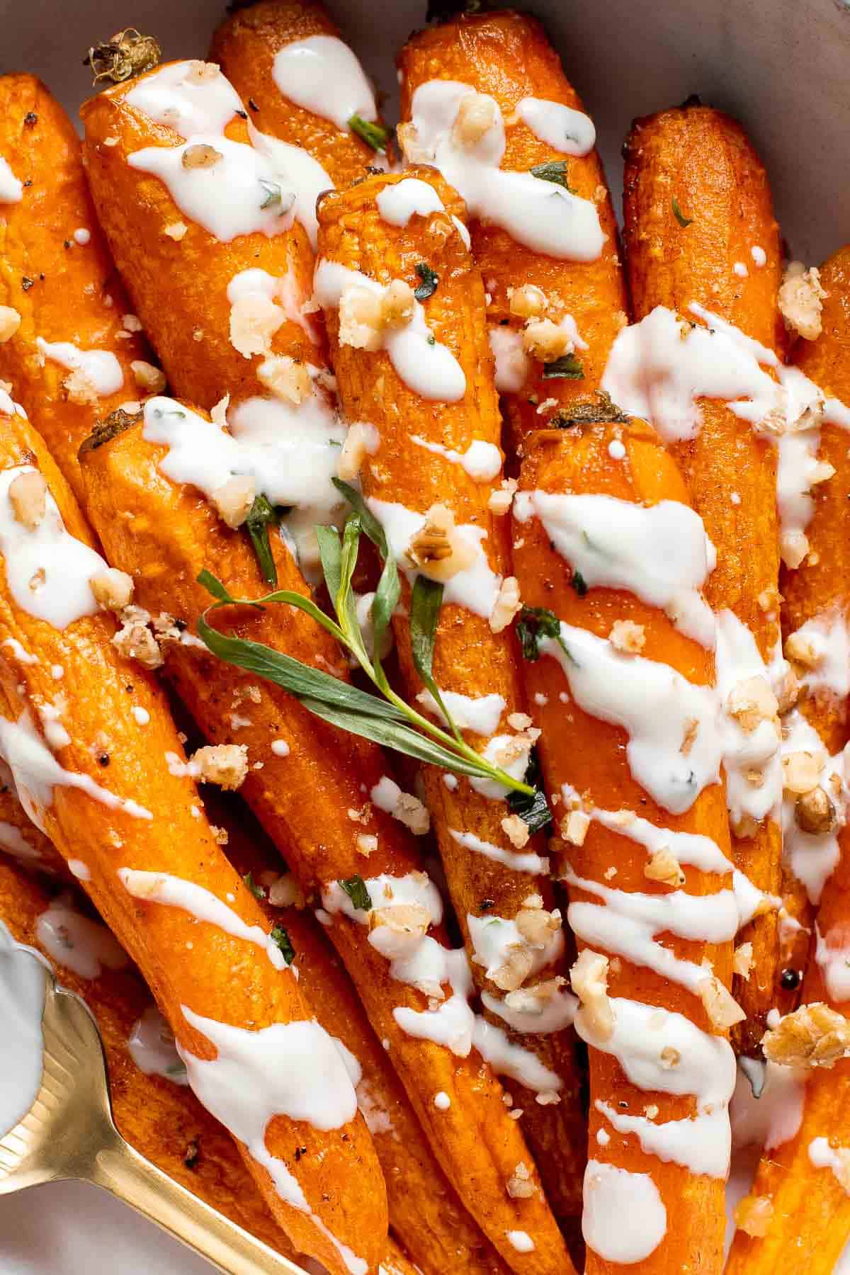 Maple Roasted Carrots with Yogurt Sauce is a quick, easy, flavorful, and delicious side dish that is warmly spiced and caramelized with maple syrup. | aheadofthyme.com