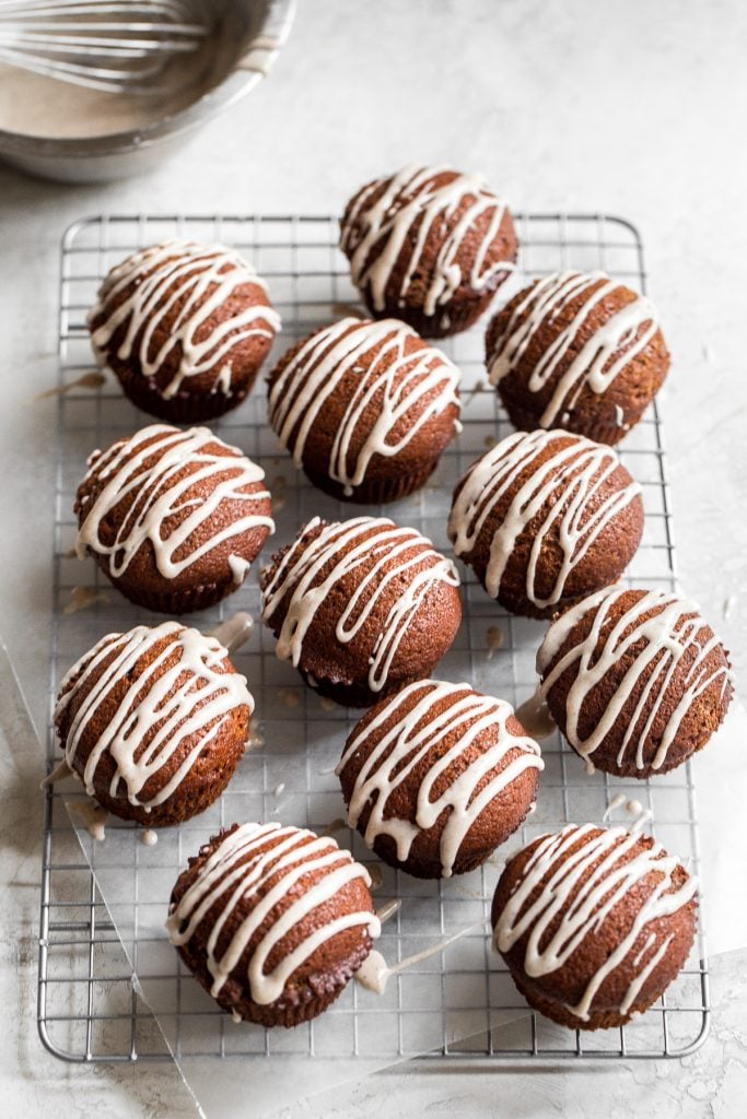 Festive gingerbread muffins with vanilla bean glaze are light, airy and fluffy with warm fragrant festive spices and rich molasses. A perfect holiday treat. | aheadofthyme.com