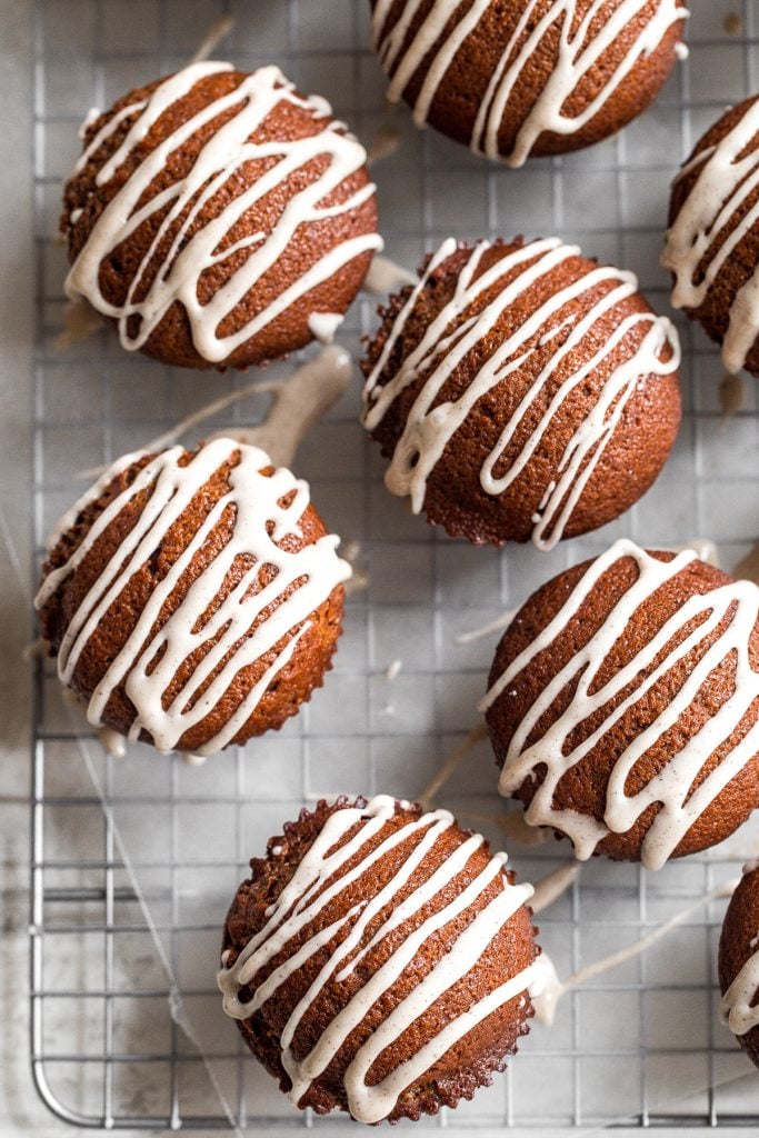 Festive gingerbread muffins with vanilla bean glaze are light, airy and fluffy with warm fragrant festive spices and rich molasses. A perfect holiday treat. | aheadofthyme.com