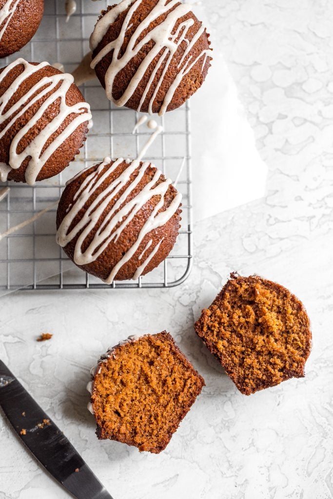 Festive gingerbread muffins with vanilla bean glaze are light, airy and fluffy with warm fragrant festive spices and rich molasses. A perfect holiday treat. | aheadofthyme.com