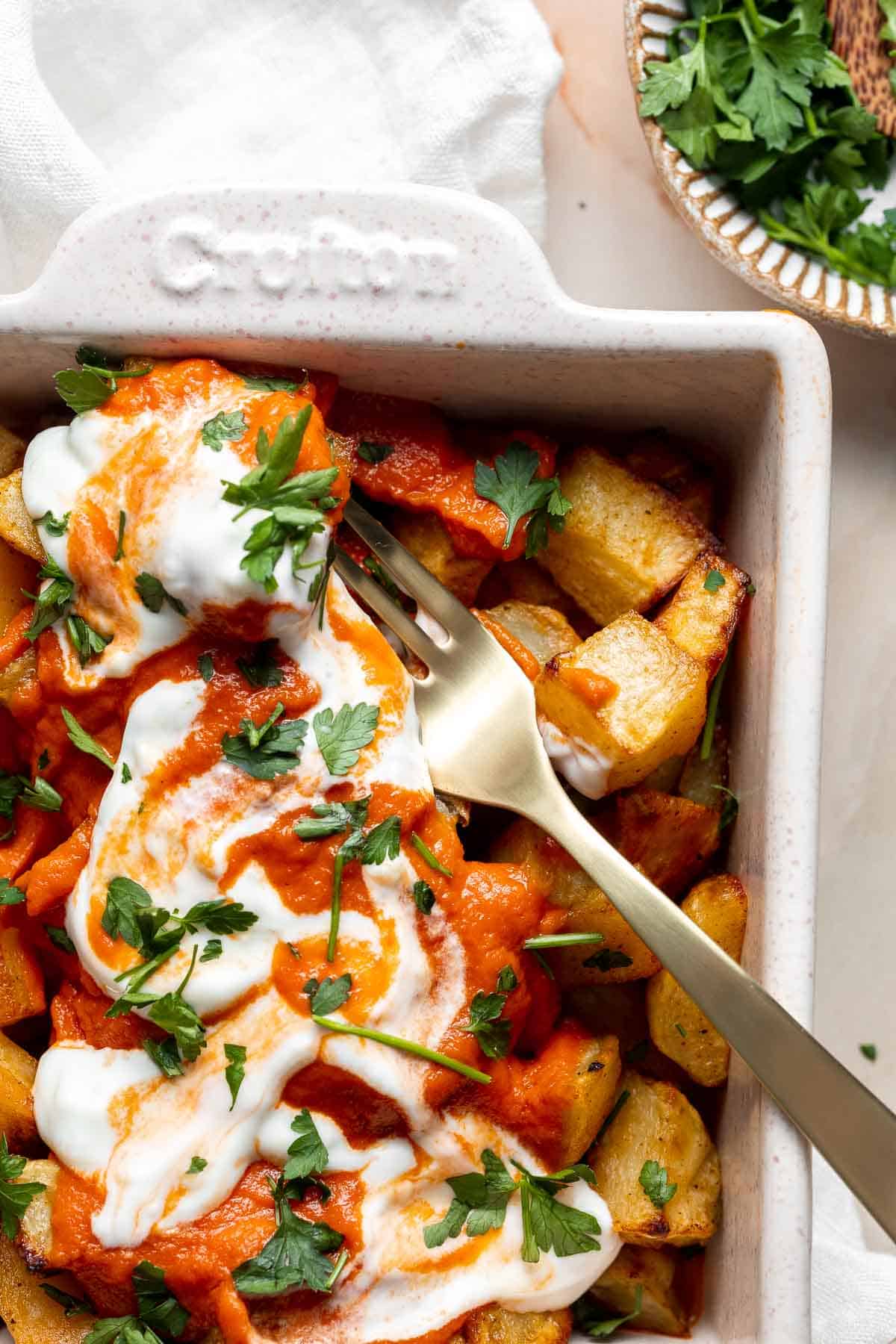 Skip the tapas bar and make Patatas Bravas at home with crispy, roasted potatoes smothered in a homemade sweet and spicy tomato sauce and garlic aioli. | aheadofthyme.com