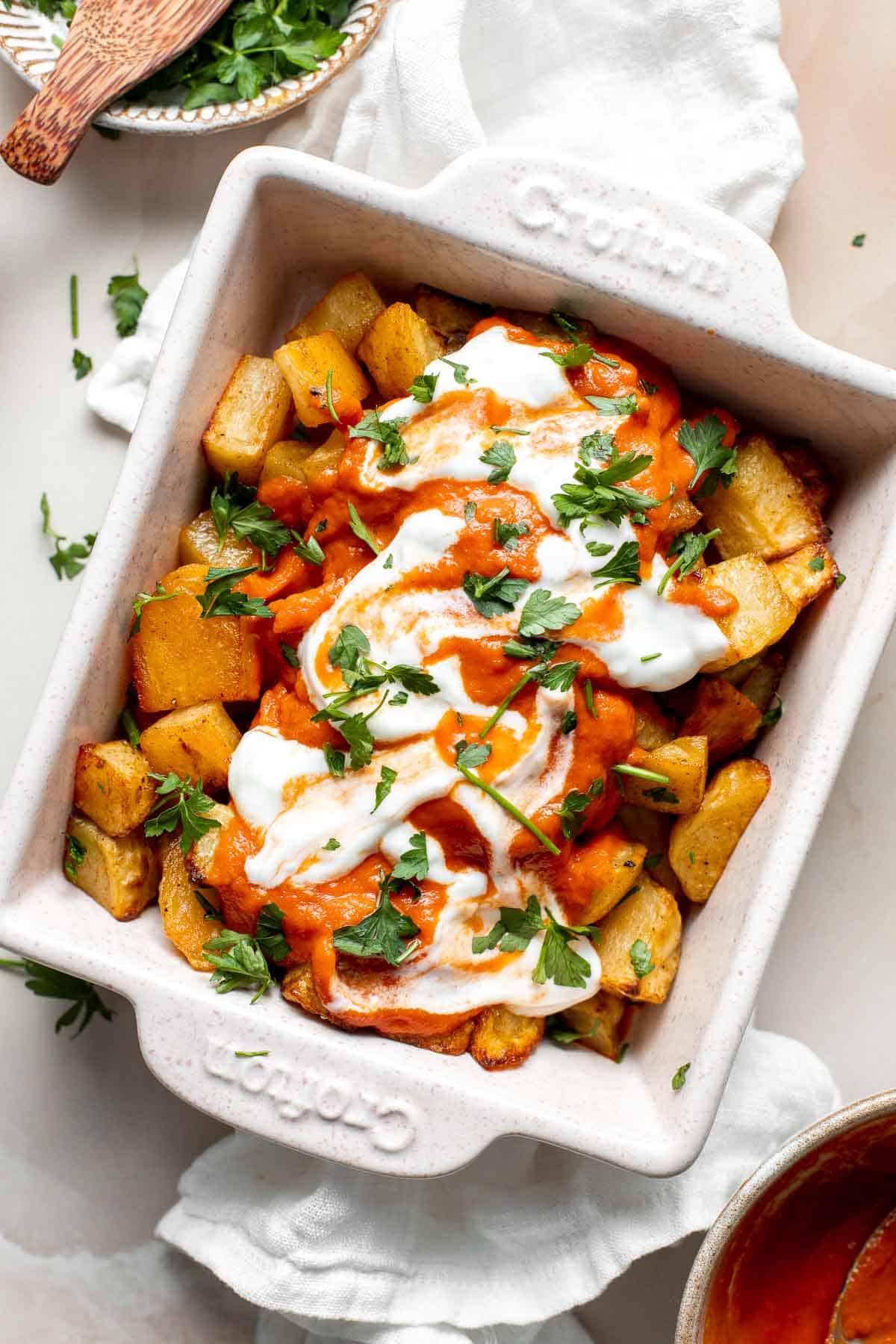 Skip the tapas bar and make Patatas Bravas at home with crispy, roasted potatoes smothered in a homemade sweet and spicy tomato sauce and garlic aioli. | aheadofthyme.com