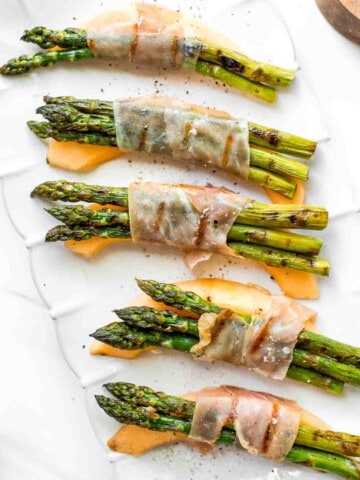 Prosciutto wrapped asparagus and melon are salty, sweet, and juicy. They are easy to make with a handful of simple ingredients, then cooked on the grill. | aheadofthyme.com