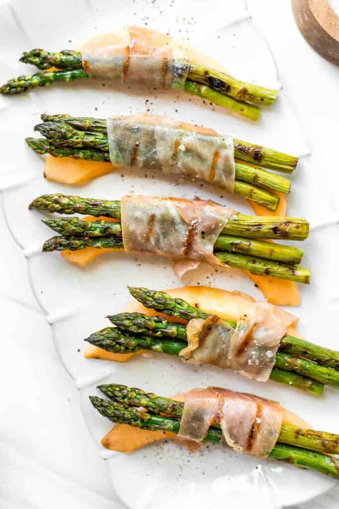 Prosciutto wrapped asparagus and melon are salty, sweet, and juicy. They are easy to make with a handful of simple ingredients, then cooked on the grill. | aheadofthyme.com