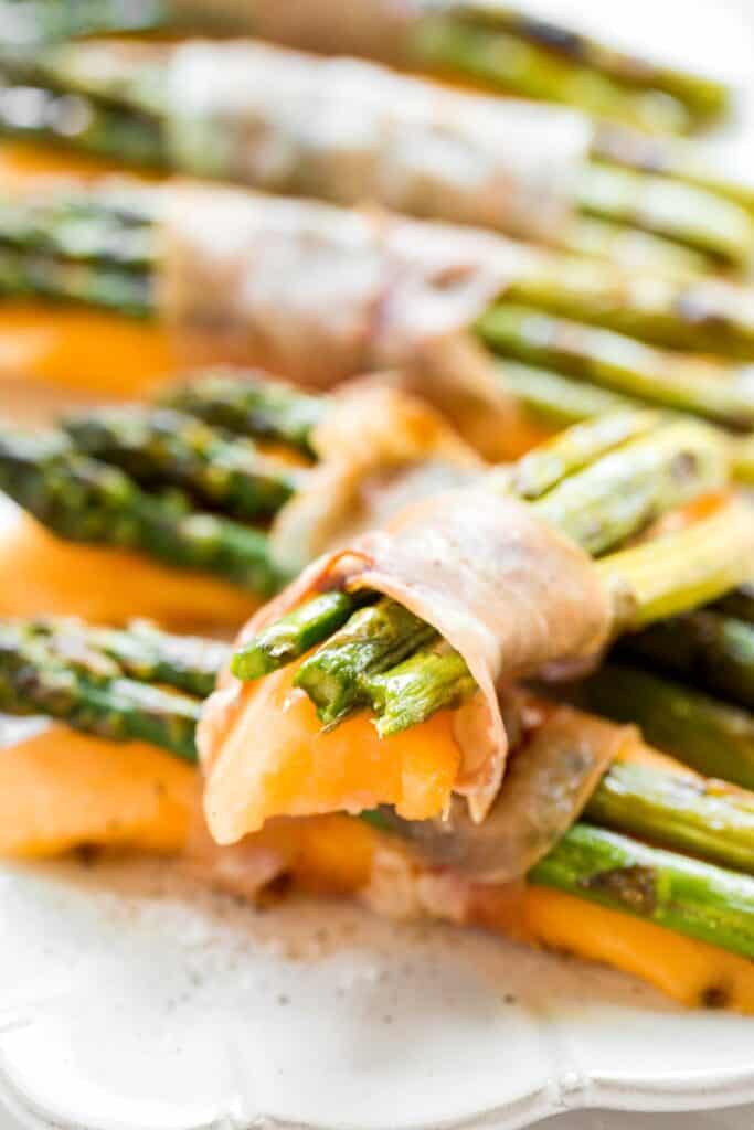 Prosciutto wrapped asparagus and melon are salty, sweet, and juicy. They are easy to make with a handful of simple ingredients, then cooked on the grill. | aheadofthyme.com