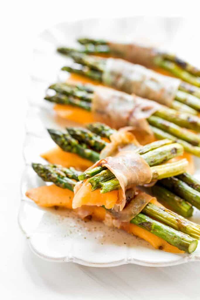 Prosciutto wrapped asparagus and melon are salty, sweet, and juicy. They are easy to make with a handful of simple ingredients, then cooked on the grill. | aheadofthyme.com