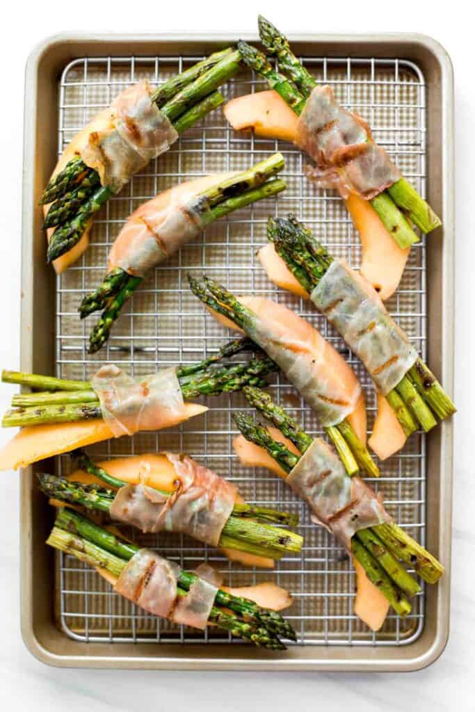 Prosciutto wrapped asparagus and melon are salty, sweet, and juicy. They are easy to make with a handful of simple ingredients, then cooked on the grill. | aheadofthyme.com