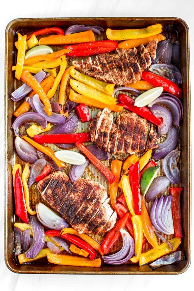 Sizzling and hot sheet pan chicken fajitas are on the table in less than 30 minutes! The best part is that you just throw everything into one sheet pan! | aheadofthyme.com