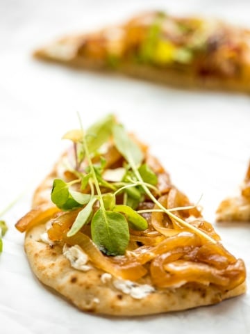 Crispy flatbread, warm, melty goat cheese with garlic and herbs, and mounds of sweet onion. You seriously cannot go wrong with caramelized onion and herbed goat cheese flatbread. | aheadofthyme.com