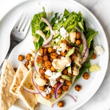 Mediterranean chickpea wedge salad combines chickpeas, crunchy vegetable toppings, and hummus dressing for a delicious deconstructed falafel flavour. | aheadofthyme.com