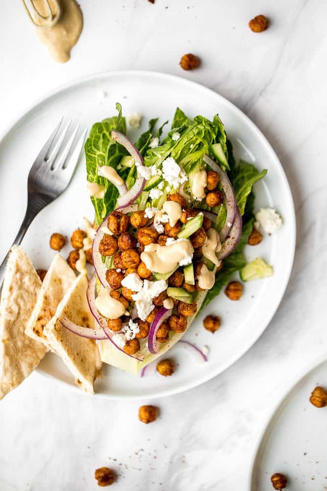 Mediterranean chickpea wedge salad combines chickpeas, crunchy vegetable toppings, and hummus dressing for a delicious deconstructed falafel flavour. | aheadofthyme.com
