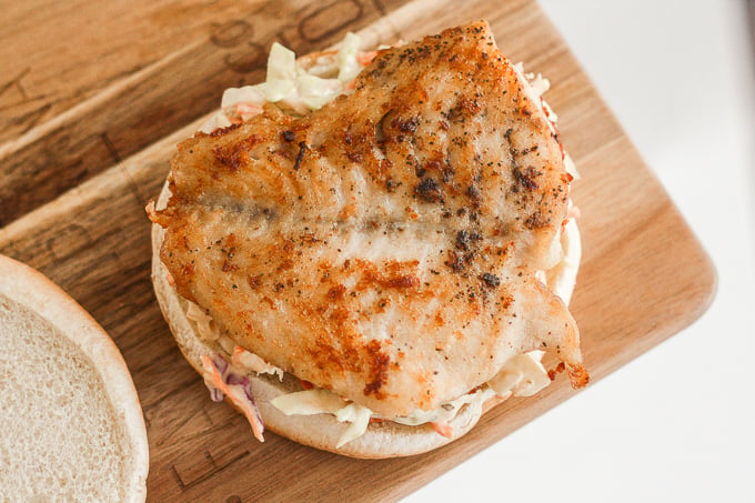 This 15-minute fish burgers with creamy slaw is juicy, flakey, and packed with flavour. So easy that it's the perfect summer weeknight meal! | aheadofthyme.com