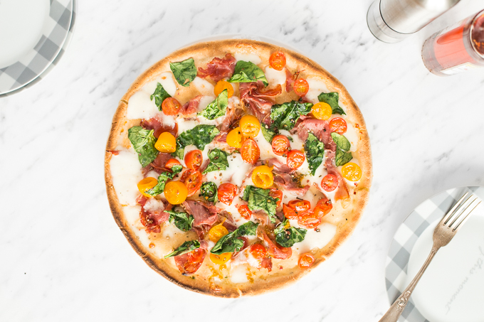 The combination of salty prosciutto, sweet tomatoes, gooey mozzarella and delicate spinach to come together to create a masterpiece -- spinach tomato and prosciutto pizza! | aheadofthyme.com
