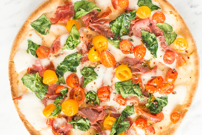 The combination of salty prosciutto, sweet tomatoes, gooey mozzarella and delicate spinach to come together to create a masterpiece -- spinach tomato and prosciutto pizza! | aheadofthyme.com