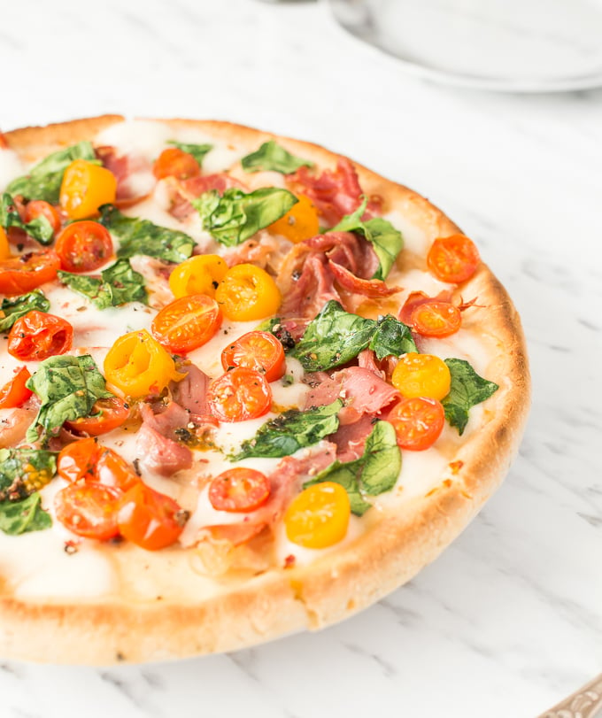 The combination of salty prosciutto, sweet tomatoes, gooey mozzarella and delicate spinach to come together to create a masterpiece -- spinach tomato and prosciutto pizza! | aheadofthyme.com