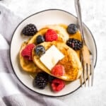 Triple berry french toast with warm slices of bread, creamy egg mixture, an overload of berries, and maple syrup drizzled on top is breakfast goals. | aheadofthyme.com