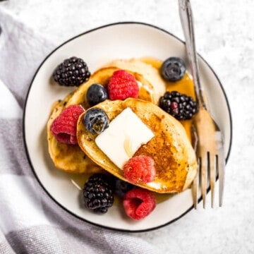 Triple berry french toast with warm slices of bread, creamy egg mixture, an overload of berries, and maple syrup drizzled on top is breakfast goals. | aheadofthyme.com